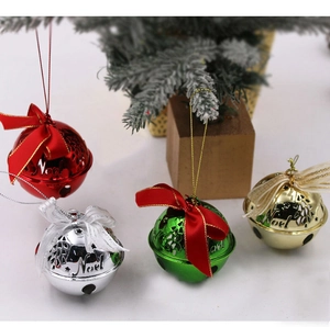Macro shot of colorful metal Noel Christmas bells with silk bows on pine branches