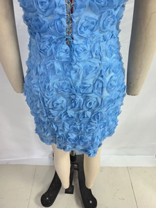 Détail de la robe courte bleu clair avec fleurs 3D et laçage au dos