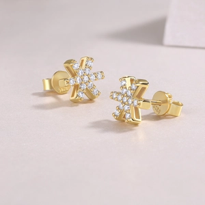 Macro shot of S925 engraved gold snowflake earrings with sparkling moissanite stones