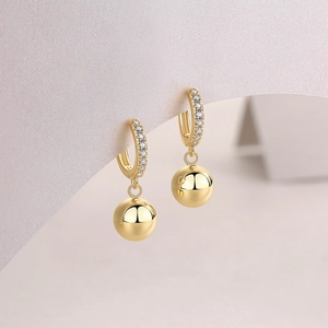 Close-up of S925 silver 18k gold earrings with moissanite pave and round ball charm