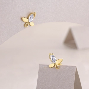 Detailed view of butterfly stud earrings with marquise-cut stone in gold finish