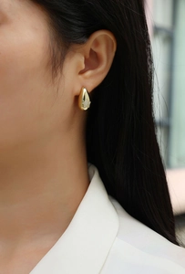 Close-up of S925 sterling silver teardrop earrings with pavé star design in gold finish