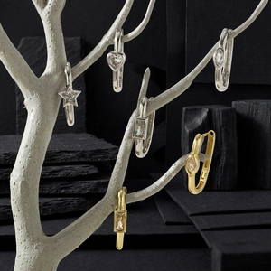 Artistic display of gold and silver huggie earrings with star and heart zircon charms