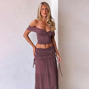 Detailed view of polka dot tiered maxi skirt with side bow tie and ruffled hemline