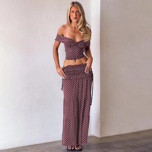 Polka dot two-piece set featuring off-shoulder crop top and tiered maxi skirt detail