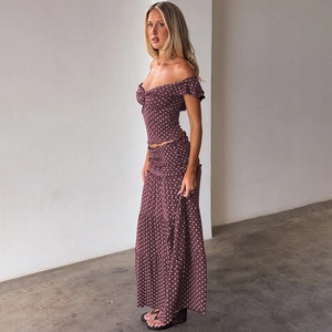 Detail of ruffled brown polka dot crop top and layered long skirt set on a model