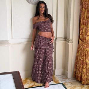 Close-up of brown polka dot crop top and high-waisted tiered maxi skirt with side bow