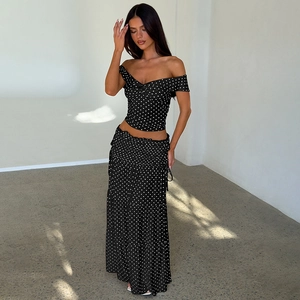 Detail of black and white polka dot maxi skirt featuring elegant side drawstring ruching