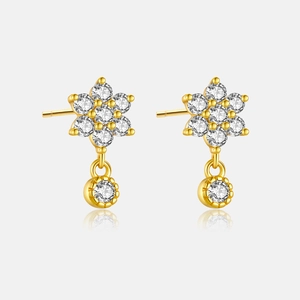 Macro shot of 925 silver gold-plated floral earrings with white round-cut gemstones