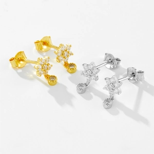 Detail of S925 sterling silver flower earrings with white zircon in gold and silver finish