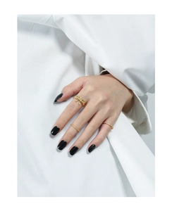 Close-up of elegant gold bow ring and sparkling pavé bands worn on fingers