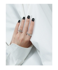 Detail of silver S925 bow ring and irregular textured lava ring on model fingers
