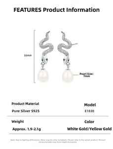 Macro detail of S925 silver snake earrings with green eyes and white pearl pendant