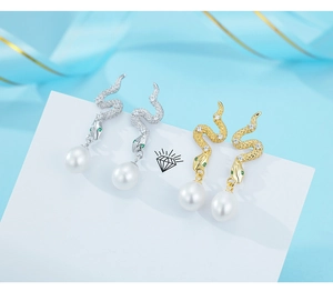 Detailed close-up of 925 silver snake earrings with white zircons and pearls