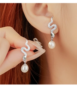 Detailed view of 925 sterling silver snake earrings with white zircons and drop pearls
