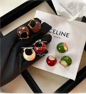 Detail of vintage enamel ball earrings in brown, burgundy, green and beige colors