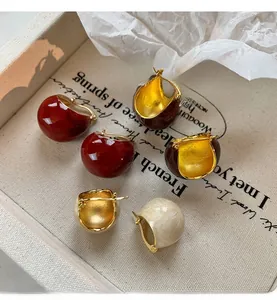 Detail view of vintage enamel dome earrings in red, brown, and cream with gold finish