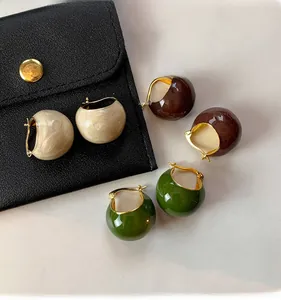 Macro view of retro enamel hoop earrings in marble beige, coffee brown, and dark green