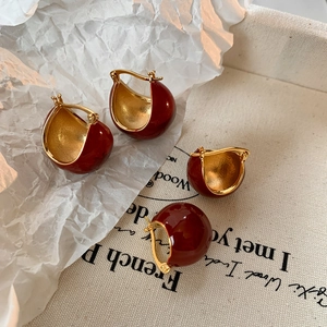 Retro red enamel dome stud earrings with luxury gold plating in a lifestyle setting