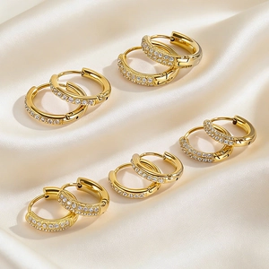 Golden stainless steel hoop earrings with micro-pave zircon crystals on silk background