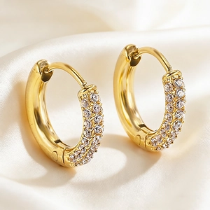 Golden huggie earrings with triple-row micro-pave cubic zirconia on white silk