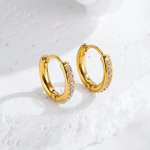Detailed macro view of gold-plated huggie earrings with micro-pave cubic zirconia inlay