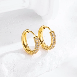 Close-up of golden huggie earrings with pave-set sparkling cubic zirconia stones