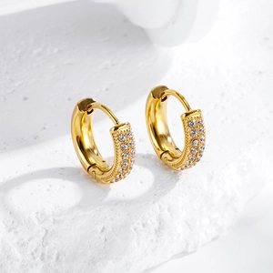 Close-up of golden stainless steel hoop earrings with double-row zircon inlay on stone