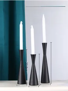 Three matte black metal candle holders of different heights for elegant home decor