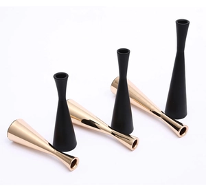 Detail view of modern black and gold metal candle holders in varied heights set