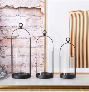Three-piece black metal lantern set with glass panels and top ring handles in tiered display