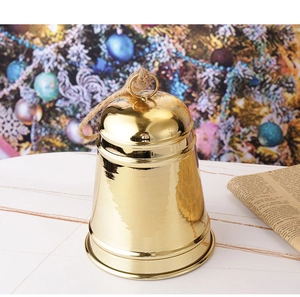 Nahaufnahme einer polierten goldenen Weihnachtsglocke mit Hanfseil auf festlichem Hintergrund