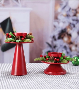 Detail von roten Weihnachtskerzenhaltern mit Beeren, Zapfen und Kiefernnadeln dekoriert
