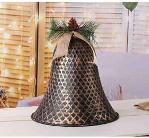 Nahaufnahme der bronzenen Weihnachtsglocke mit Tannenzapfen, Beeren und Leinenschleife