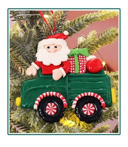 Detailansicht eines Weihnachtsmanns im grünen LKW als Anhänger am Weihnachtsbaum