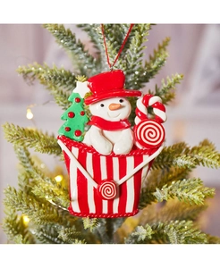 Detail eines Schneemann-Anhängers im Süßigkeiten-Eimer an einem Weihnachtsbaum