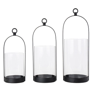 Three-piece black metal minimalist candle holder set with glass shades on white background