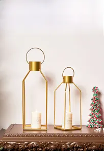 Modern gold geometric metal candle holders with rectangular frames and top ring handles