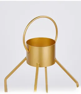 Detail of gold metal candle holder featuring a portable handle and smooth circular base