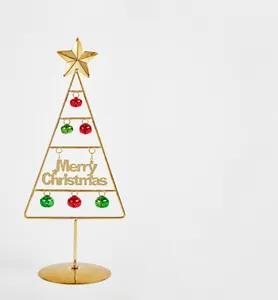 Detailansicht eines goldenen Weihnachtsbaums aus Metall mit roten und grünen Glocken