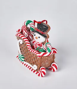 Makro-Detail vom weihnachtlichen Lebkuchen-Schlitten mit Schneemann und Zuckerstangen