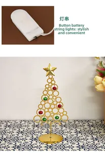 Makroaufnahme vom goldenen Metall-Weihnachtsbaum mit Glocken und LED-Batteriefach