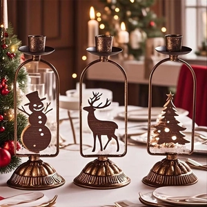 Détail de bougeoirs en métal vintage avec silhouettes de bonhomme de neige et cerf
