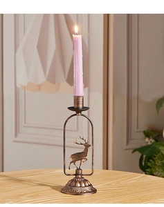 Détail d'un bougeoir en bronze vintage avec motif cerf et relief sur une table en bois