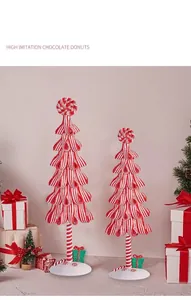 Nahaufnahme rot-weiß gestreifter Mini-Weihnachtsbäume mit spiralförmigen Zuckerstangen-Kugeln