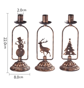 Détail de bougeoirs en métal bronze vintage avec silhouettes de bonhomme de neige et cerf