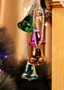 Nahaufnahme bunter Weihnachtsglocken aus Metall mit Glanzeffekt und geflochtener Schnur