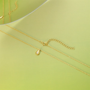 Detail of gold water drop necklace with clear gemstone pendant and lobster clasp closure