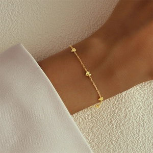 Close-up of minimalist S925 sterling silver heart charm bracelet in golden finish