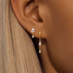 Macro shot of gold S925 earrings featuring pear-cut cubic zirconia in a refined setting